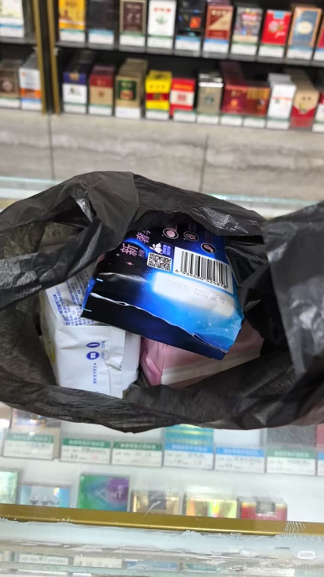 A packet of sanitary pads inside a black plastic bag.