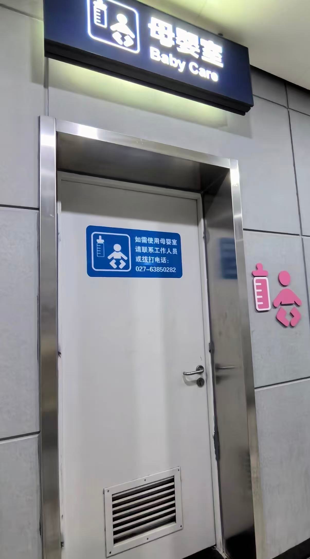 A closed baby-care room door with a sign asking visitors to contact staff.